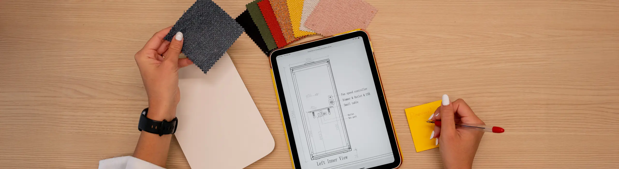 Fabric swatches and a tablet with a booth drawing