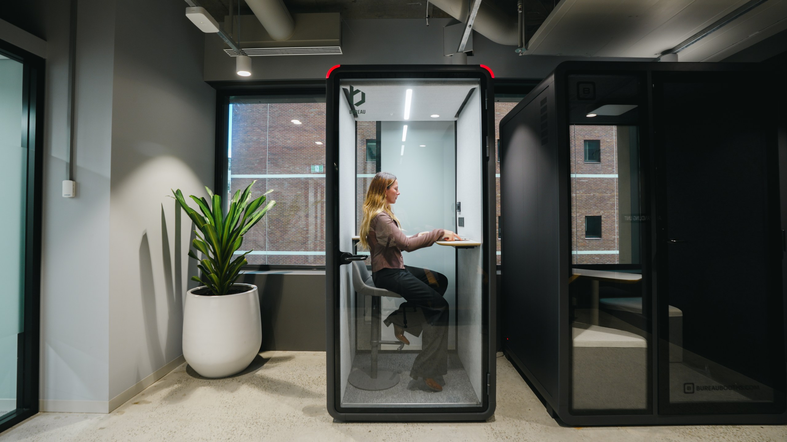 Person working in a Bureau One booth in an open-plan office